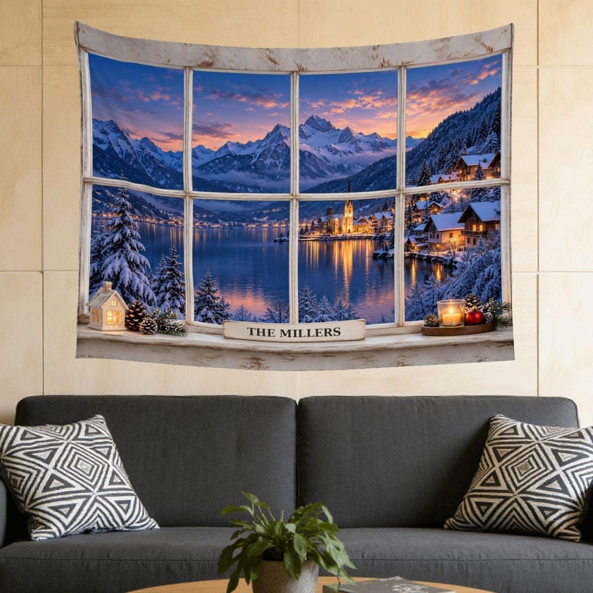 Christmas tapestry above a sofa: a fake window with a white frame and a snowy lakeside village at dusk, with the sample family name The Millers on the sill. Cozy Christmas wall decor and holiday decor for the living room.